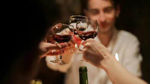 Gläser heben sich zum Anstoßen bei einem festlichen Abendessen.