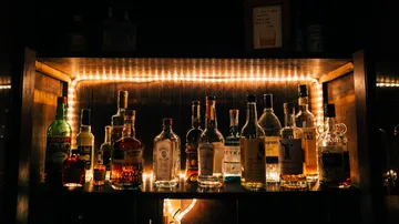 bottle in a dark bar surrounded by lights.