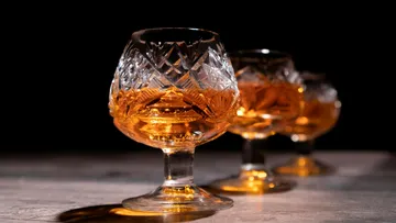 Glasses of golden drink are on a table.