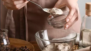 Eine Hand schöpft eine Mischung in ein Glas.