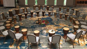 Chairs and drums form a circle in space.