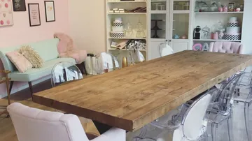 Holztisch in einem hellen Raum, umgeben von Stühlen.