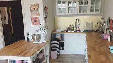 Küche mit Mixer, Arbeitsfläche und Geräten im hellen Raum.
