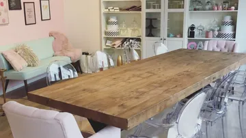 Holztisch in hellen Raum, umgeben von modernen Stühlen.