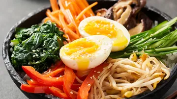 Bowl of rice, vegetables and soft-boiled eggs.