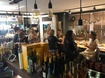 Frauen feiern in einer Bar mit Getränken und Dekoration.