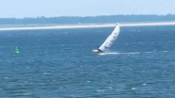 Ein Segelboot fährt schnell über das Wasser.