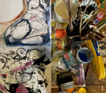 Painting on paper surrounded by painting supplies and paints.