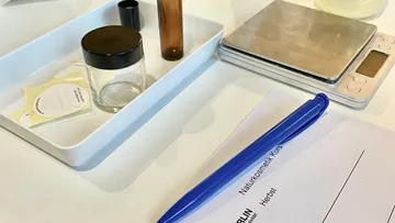 Bowl with containers and scale, for mixing cosmetics.