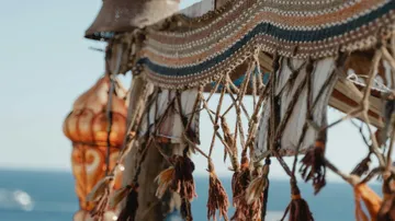 Hanging decorative fabrics gently blow on the beach.