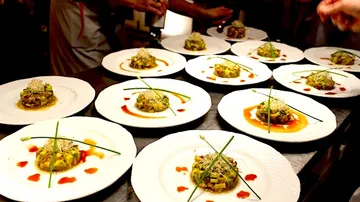 Various plates of artfully prepared food are served.