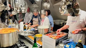 Group cooks together in a modern kitchen with pots.