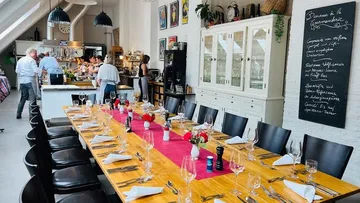 Long table with covered seats in a bright room.