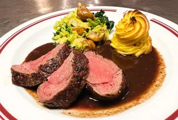 Rinderfilet mit Beilage und Sauce auf einem Teller.