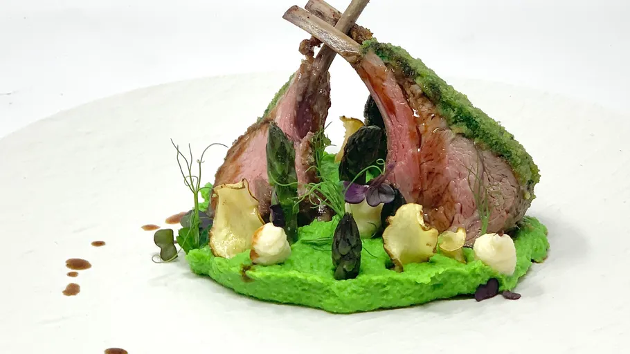 Lamb chops lie on a green pea puree base.