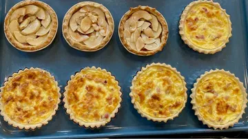 Dessert-Törtchen backen, auf einem blauen Blech platziert.