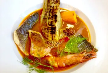 Fischgerichte in Brühe mit Gemüse und Gewürzen serviert.