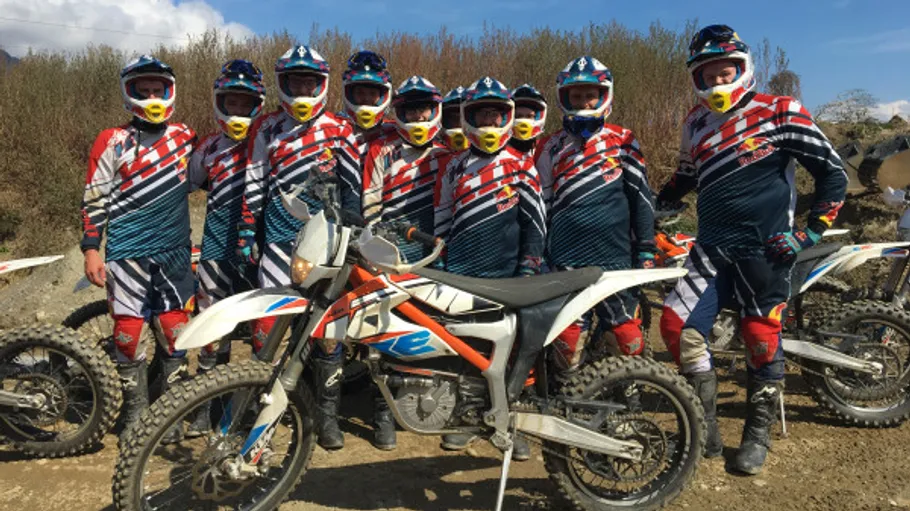 Motorradfahrer stehen in Gruppe vor Motorrädern in der Natur.