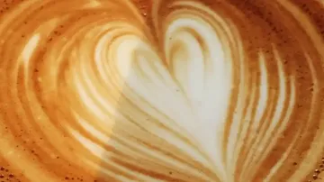 Kaffeeoberfläche zeigt herzförmige Latte-Art-Muster.