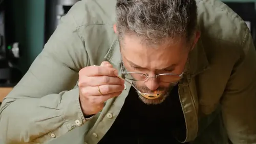 A man eats from a bowl with a spoon.
