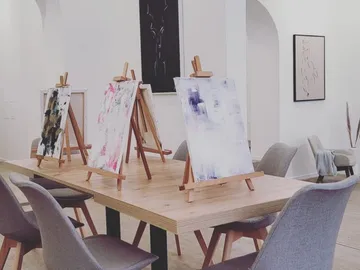 There are three easels with pictures on a table.