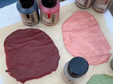Farben sind nebeneinander auf Papier verteilt.