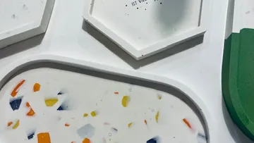 Bunte Tischobjekte in verschiedenen Formen liegen auf einer Oberfläche.