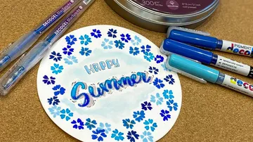 Buntes Papier mit `Happy Summer`, umgeben von Stiften.