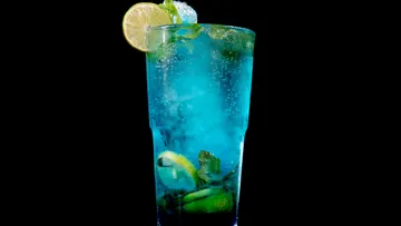Blaue Limonade mit Limette und Minze in einem Glas.