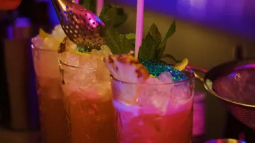 Cocktails mit Eis werden in einer Bar vorbereitet und dekoriert.