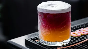 Bunter Cocktail steht auf einer Baroberfläche.