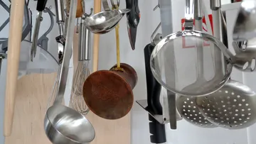 Kitchen tools hang on a hook in the kitchen.