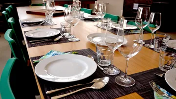 Table set with glasses and crockery for a meal.