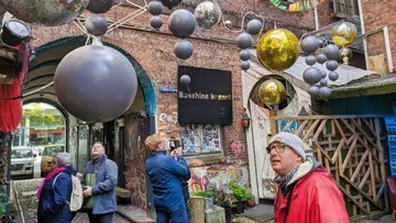 Large decorative balls hang, people look at them with fascination.