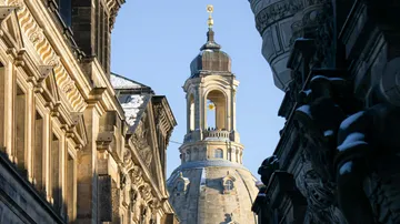 Türmchen ragt über die Häuser zwischen historischer Architektur.