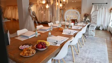 Wooden table with food, set for a meeting in a room.