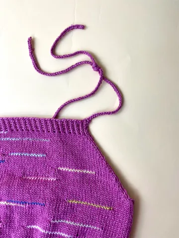 Purple knitted piece with long threads due to