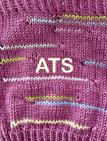 Purple knitted pattern with colorful stripes, text visible
