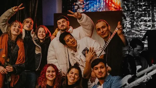 Group of young people pose happily in lively surroundings.