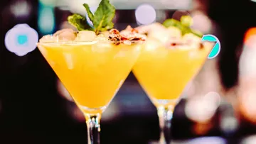 Zwei Cocktails stehen auf einem Tisch, mit Eis und Pfefferminze.