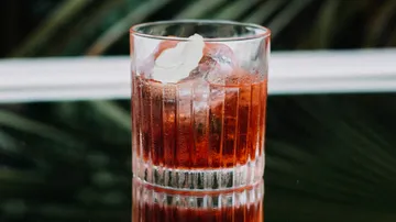 Ein Glas mit rotem Getränk steht auf einem Tisch.