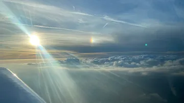 Two suns with rays across cloud cover in the sky.