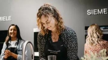 Woman cooks concentrated in a modern kitchen environment with appliances.