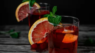 Zwei Gläser mit rotem Getränk, dekoriert mit Zitrone und Minze.