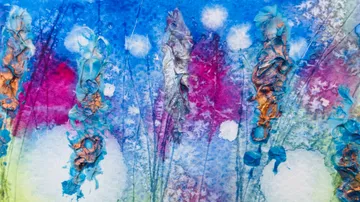 Bright, abstract colors form blooming plants in the background.