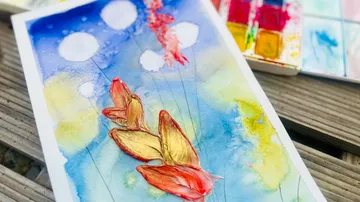 Watercolor painting shows colorful fish in the water background.