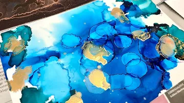 Farbige Tinte auf Papier bildet abstrakte, fließende Muster.