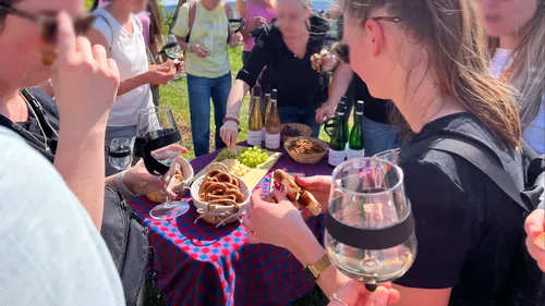 Group enjoying pretzels and wine at a table.