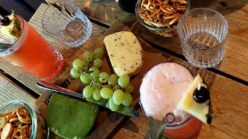 Bunte Getränke und Snacks auf einem Holztablett.