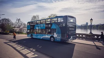 A double-decker bus runs along a waterfront in Hamburg.